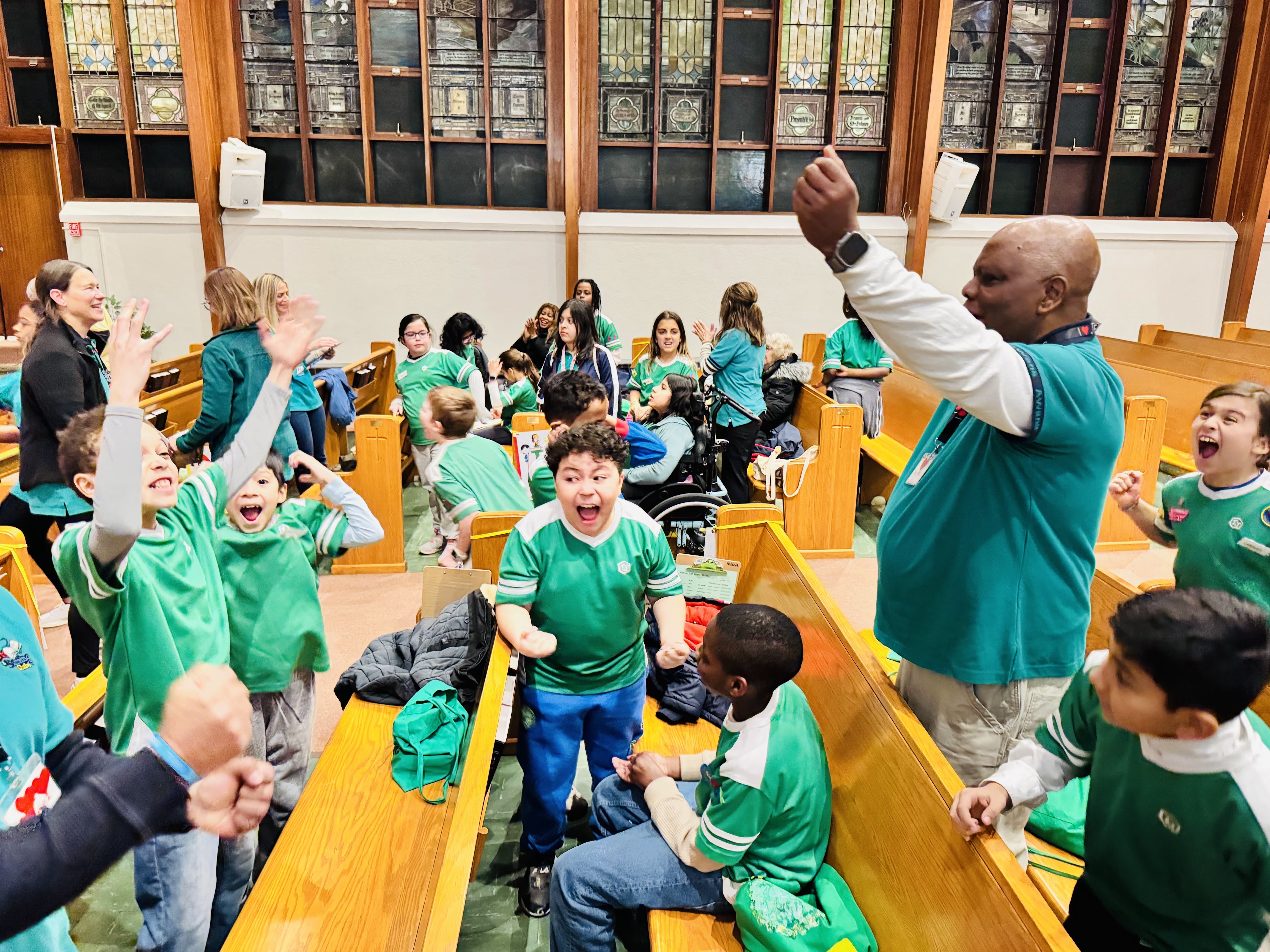 Group of older children cheering around a table